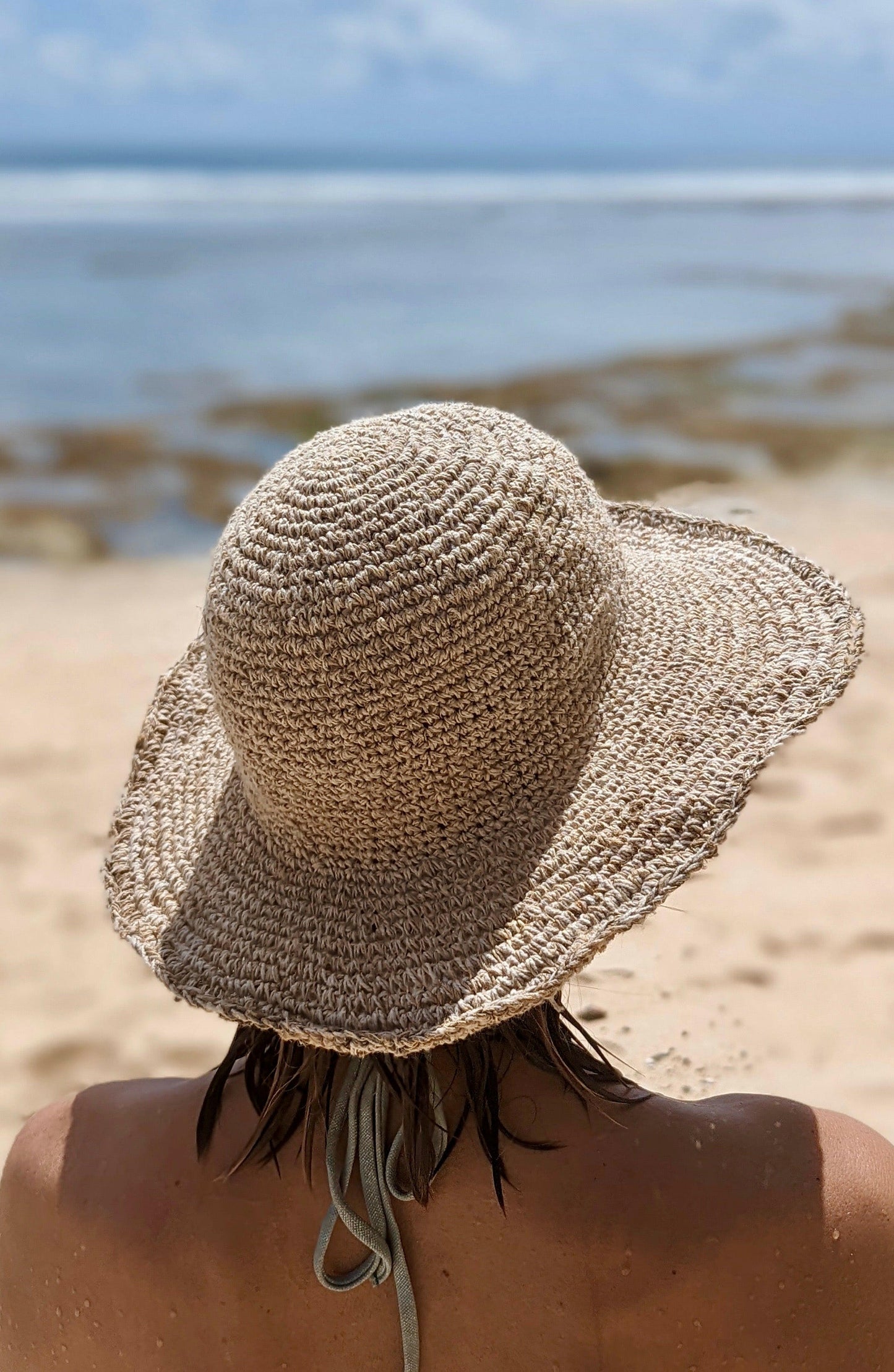 Woman wearing eco-friendly sun hat on beach in Australia