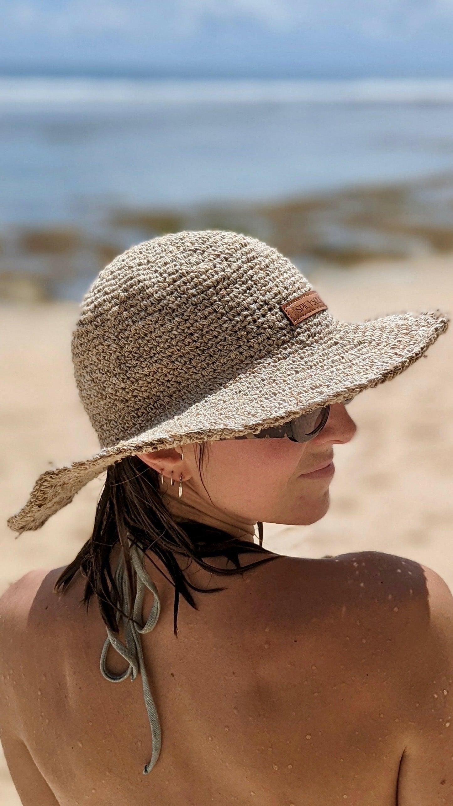 Woman wearing sustainable sun hat on beach in Australia