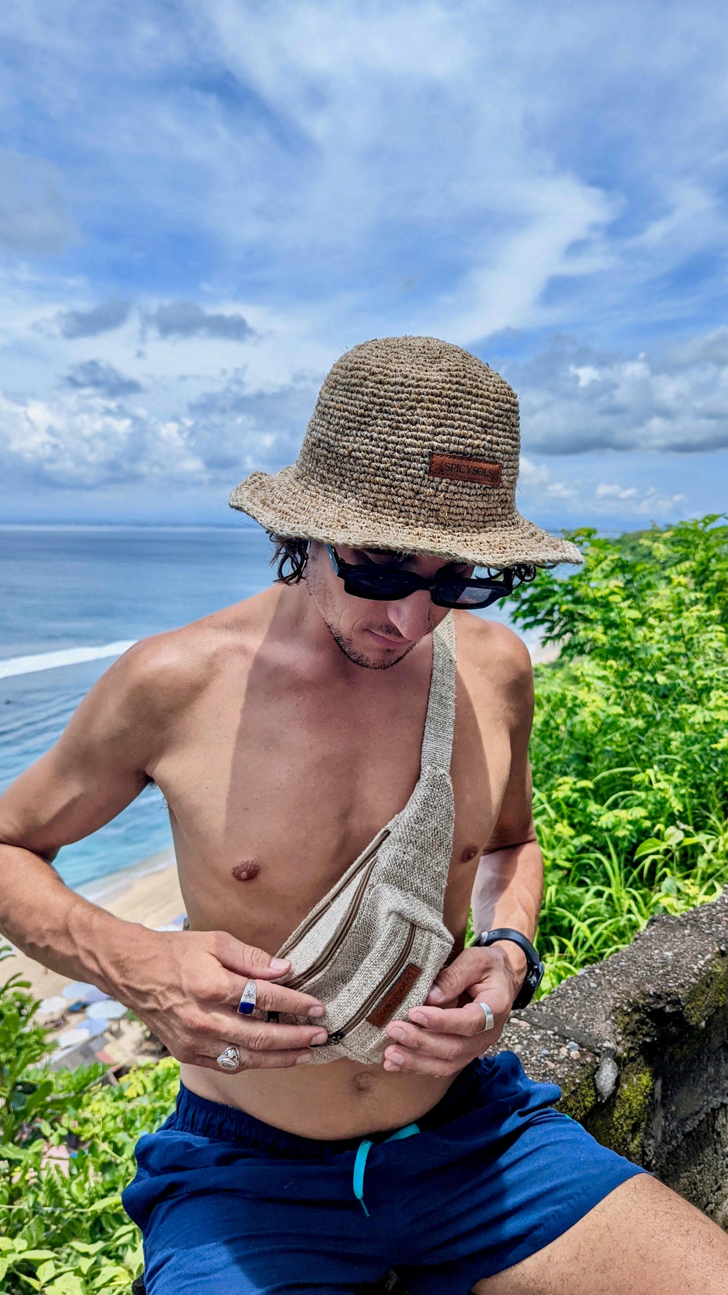 Man wearing sustainable hat and hemp bumbag on beach Australia