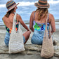 Girls laughing while wearing ethical hemp hats and sustainable tote bags on beach in New Zealand