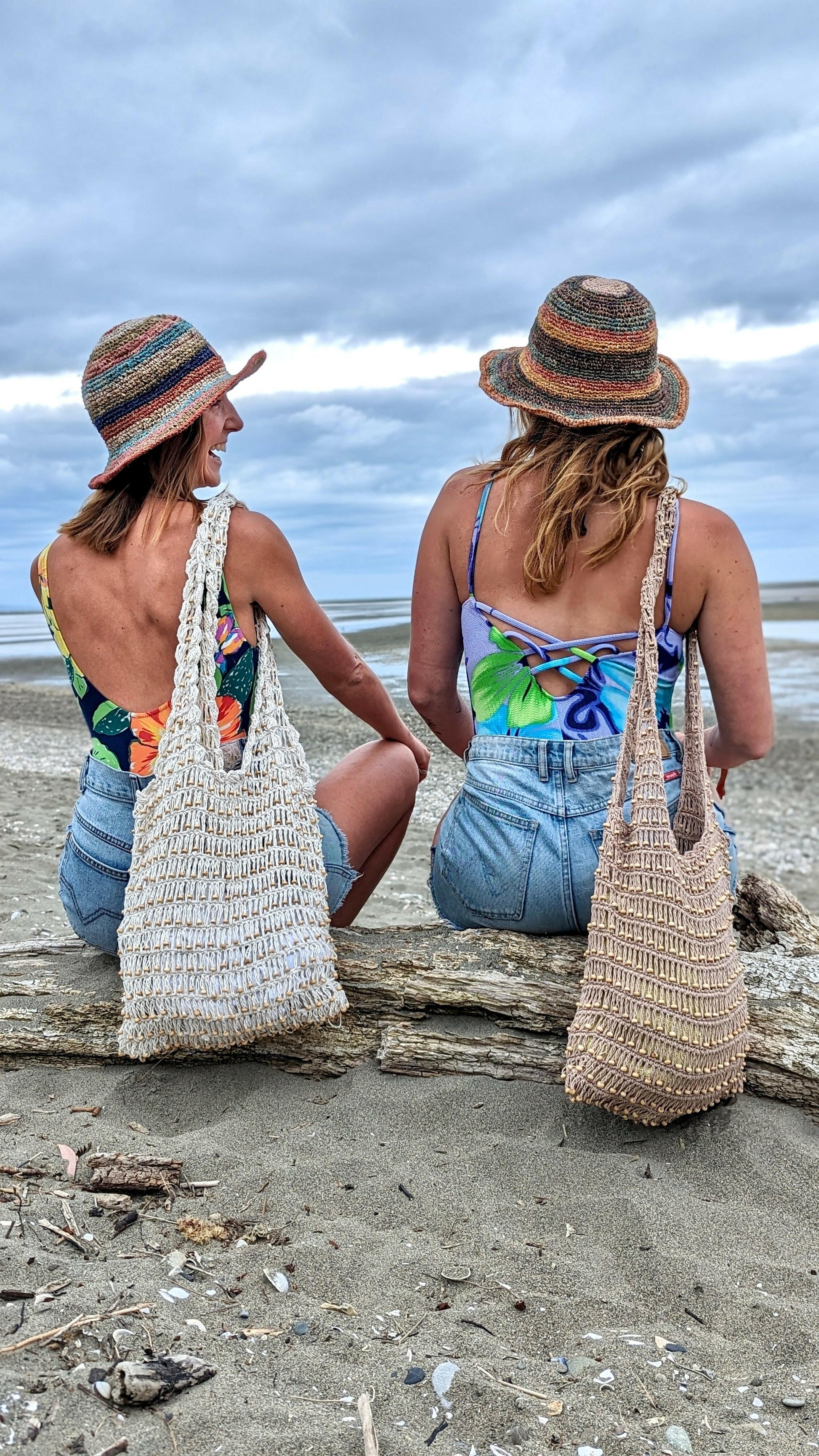 Girls laughing while wearing ethical hemp hats and sustainable tote bags on beach in New Zealand