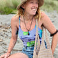 Girl smiling while wearing sustainable bucket hat and tote bag on beach