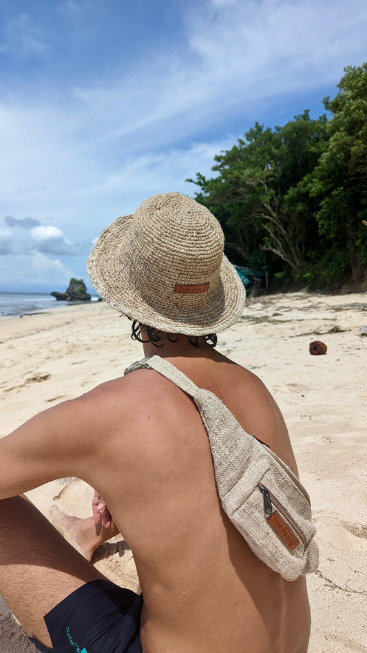 Man wearing sustainable hat and hemp bumbag on beach Australia